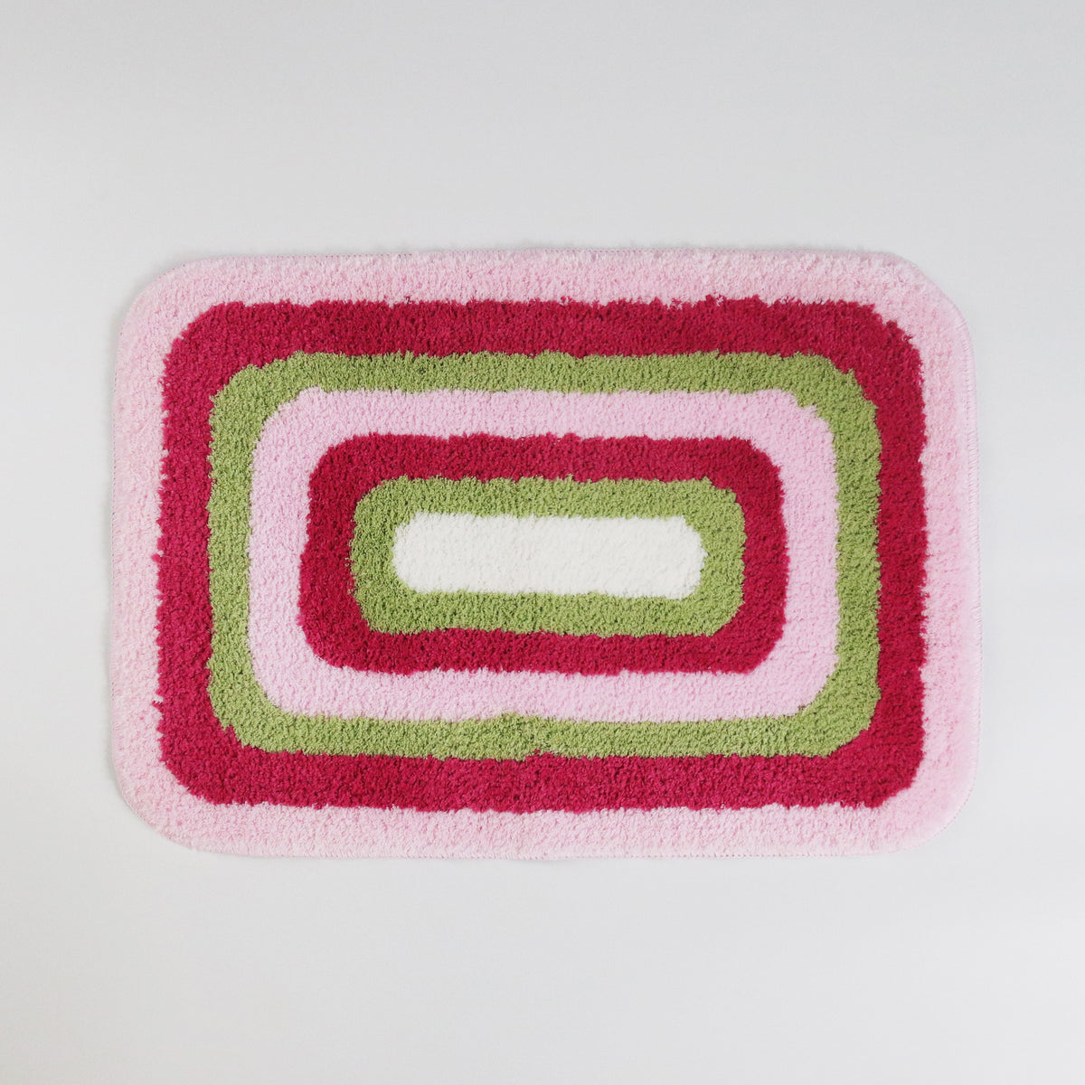 Feblilac Red Green and White Greek Key tufted bath mat in a bright bathroom beside the bathtub