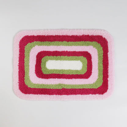 Feblilac Red Green and White Greek Key tufted bath mat in a bright bathroom beside the bathtub