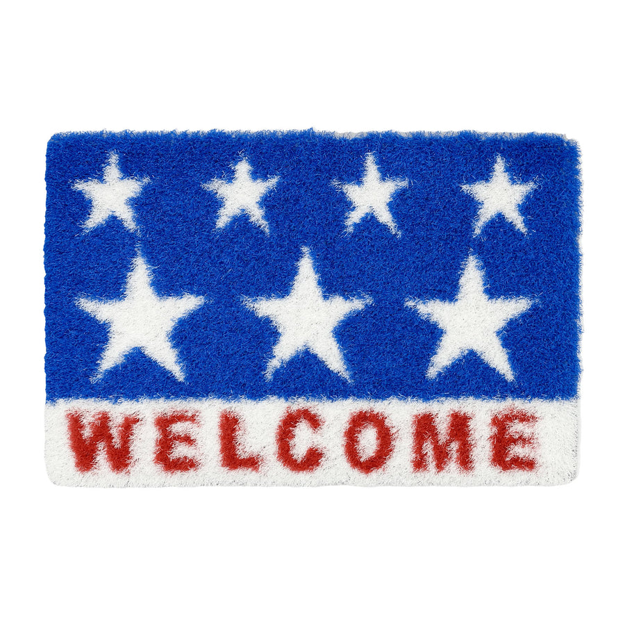 Feblilac Stars and Stripes Welcome PVC coil door mat in front of a bathroom vanity with fresh towels