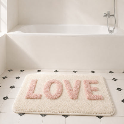 Feblilac LOVE tufted bath mat on black-and-white diamond tile with built-in tub