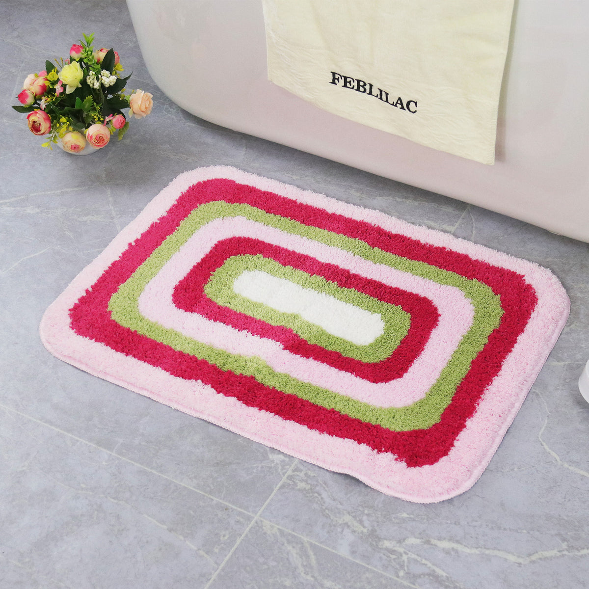 Feblilac Red Green and White Greek Key tufted bath mat on a wood floor next to a soaking tub