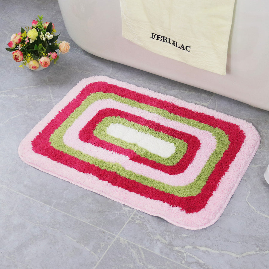 Feblilac Red Green and White Greek Key tufted bath mat on a wood floor next to a soaking tub