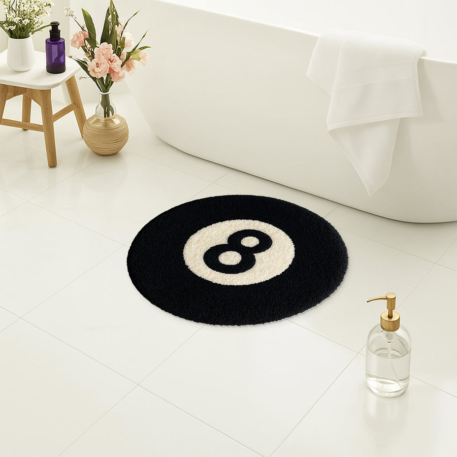 Feblilac 8 Ball tufted bath mat on a wood floor next to a soaking tub