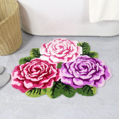 Feblilac Three Flowers tufted bath mat on a wood floor next to a soaking tub