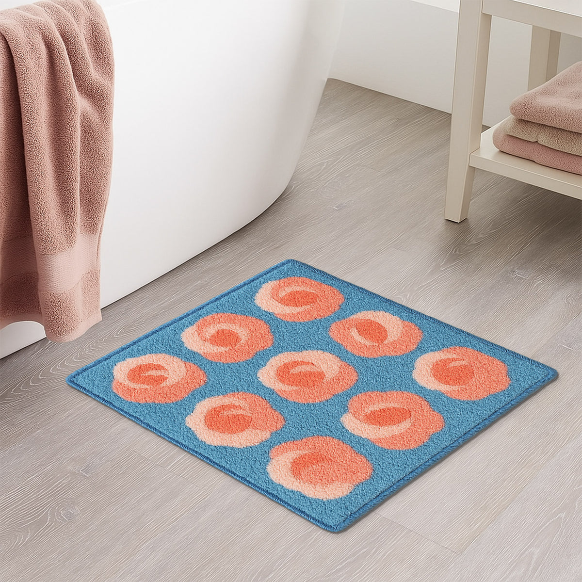 Feblilac Roses on Blue tufted bath mat in front of a bathroom vanity with fresh towels