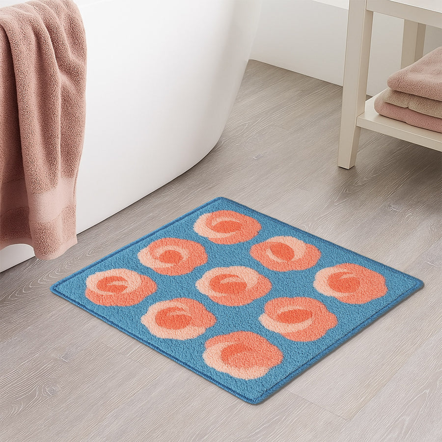 Feblilac Roses on Blue tufted bath mat in front of a bathroom vanity with fresh towels