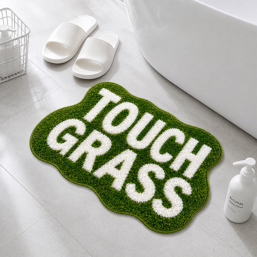 TOUCH GRASS green tufted rug by a bathtub with white slippers and towel basket