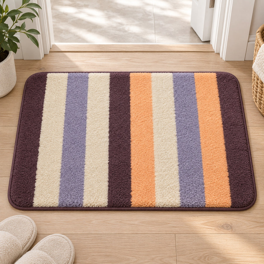 Feblilac Orange and Purple Stripes tufted bath mat in front of a bathroom vanity with fresh towels