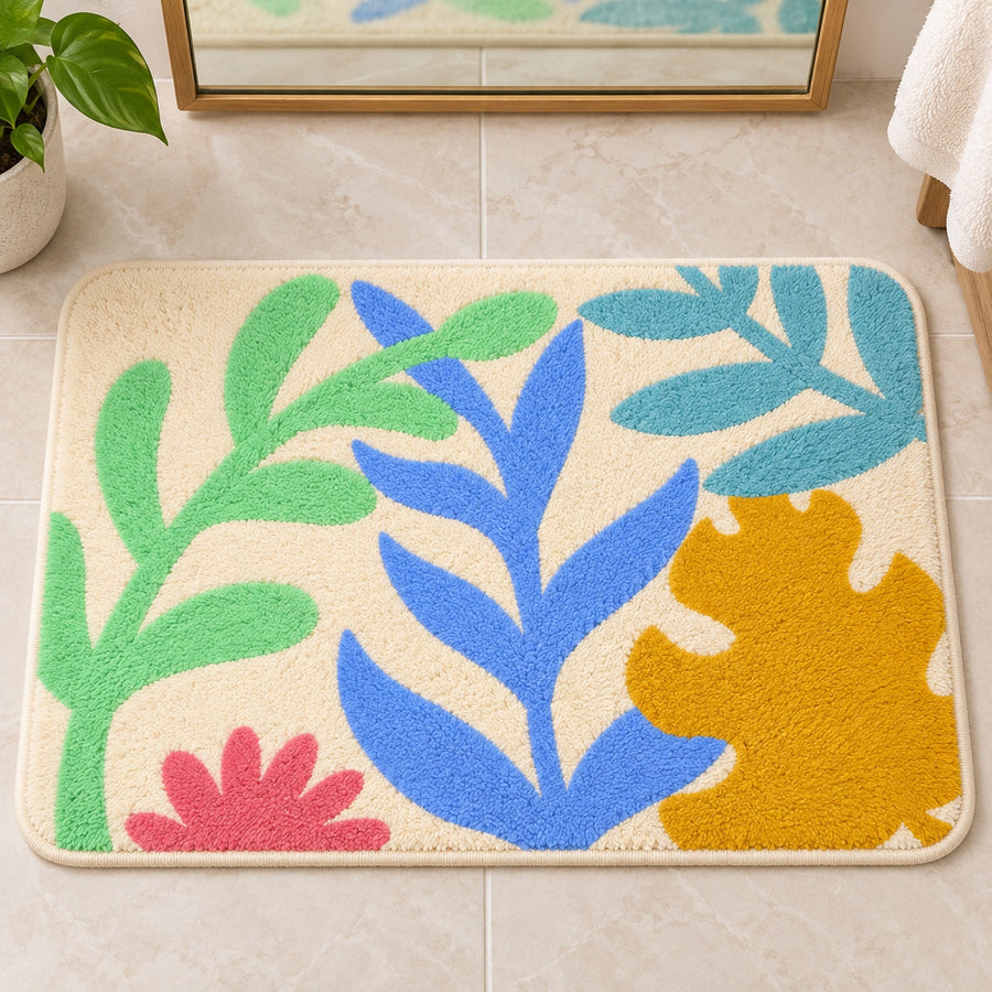 Feblilac Colorful Tropical Leaves tufted bath mat on a wood floor next to a soaking tub