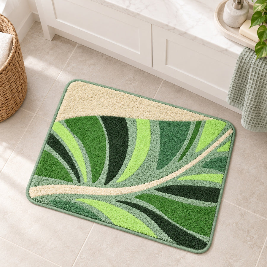 Feblilac Flowing Green Leaves tufted bath mat on a wood floor next to a soaking tub
