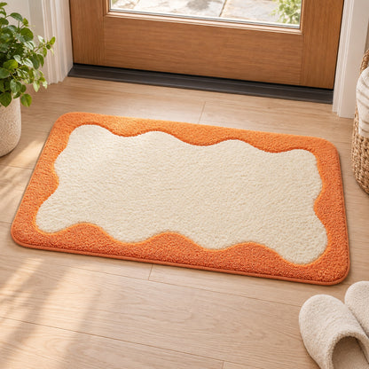 Feblilac Orange Wavy Border tufted bath mat on a light wood floor at the doorway