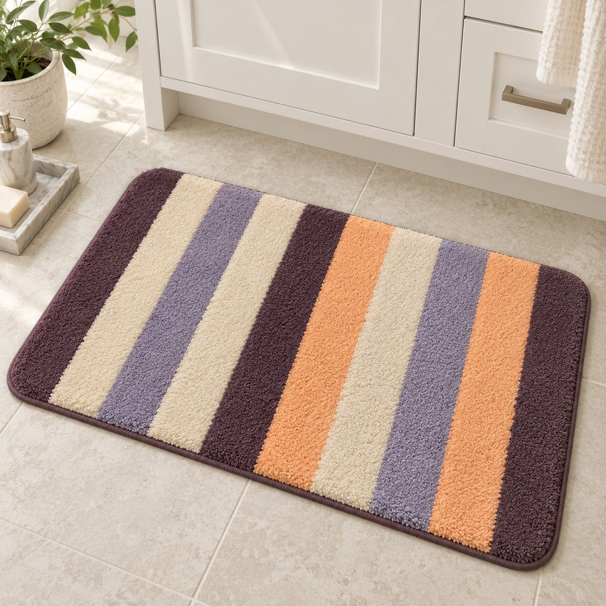 Feblilac Orange and Purple Stripes tufted bath mat in a sunny bathroom with a potted plant