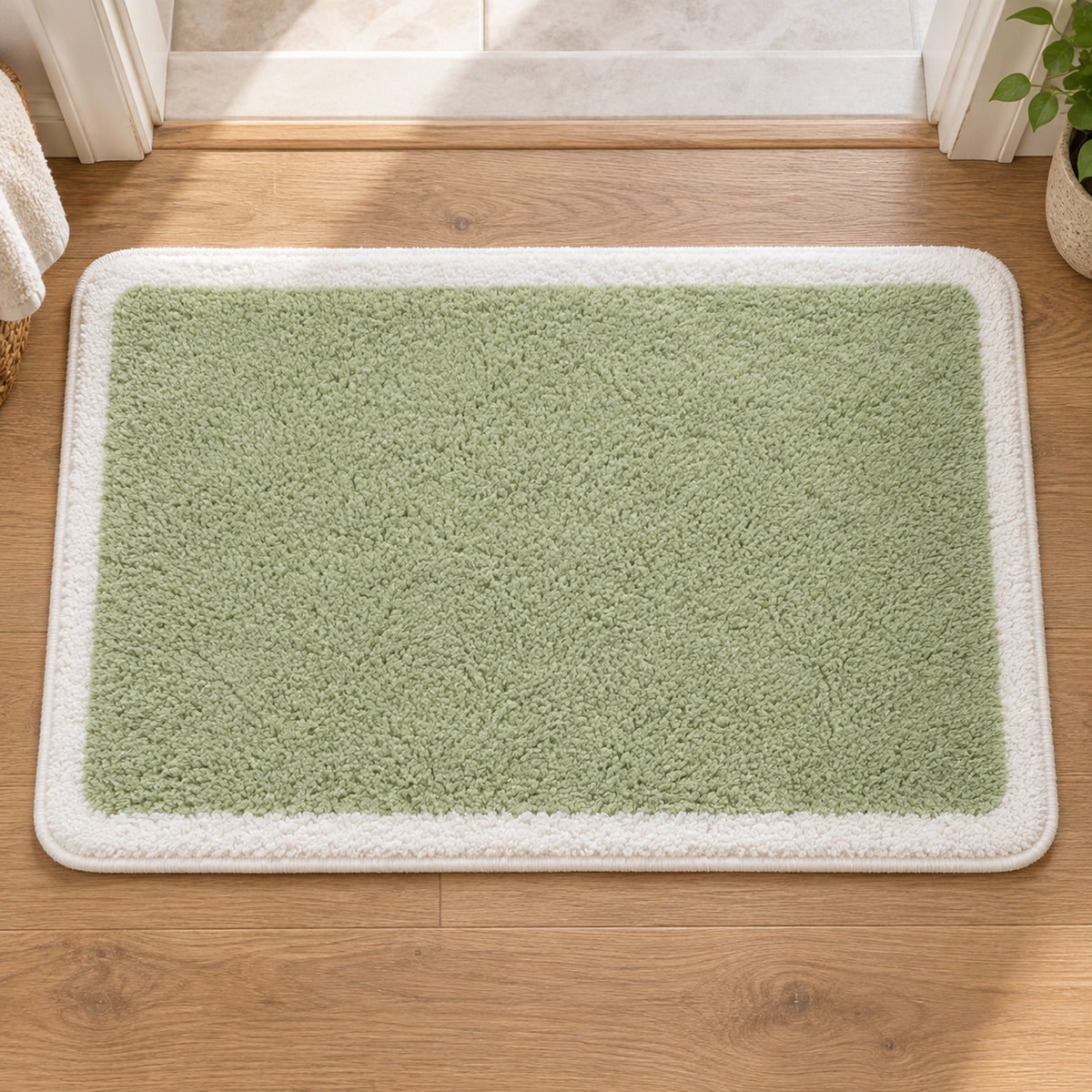 Feblilac Green with White Border tufted bath mat in a sunny bathroom with a potted plant