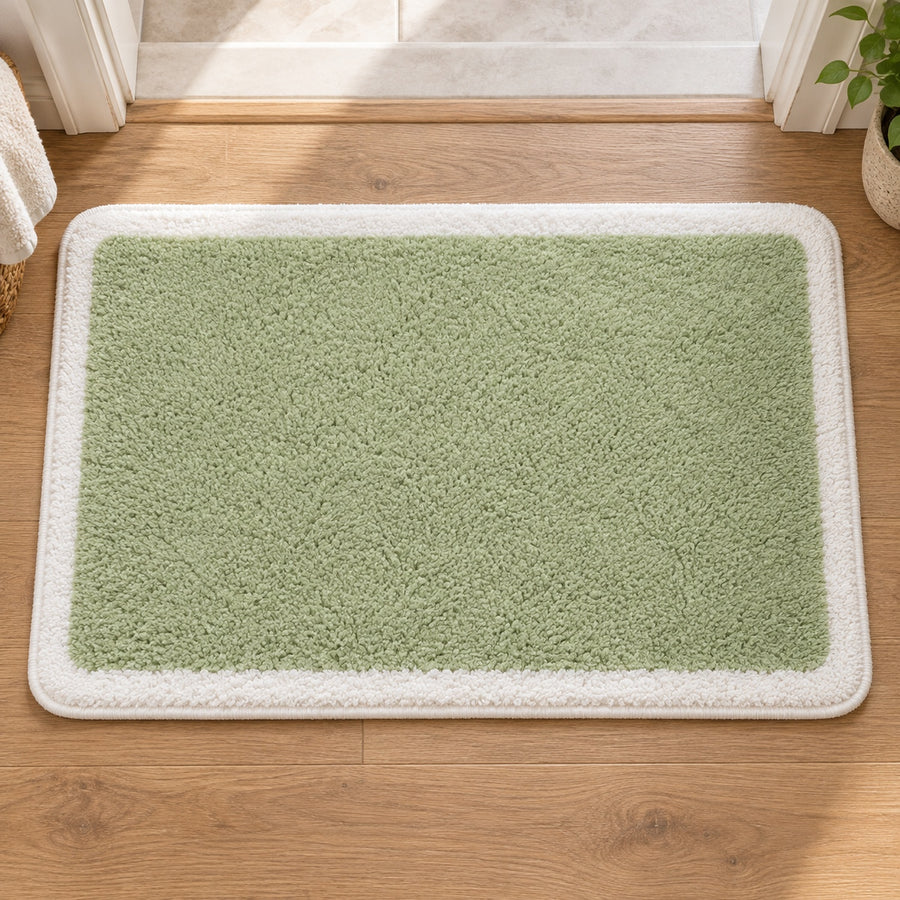 Feblilac Green with White Border tufted bath mat in a sunny bathroom with a potted plant