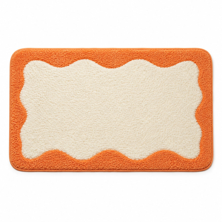 Feblilac Orange Wavy Border tufted bath mat in a bright bathroom with a potted plant