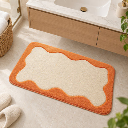 Feblilac Orange Wavy Border tufted bath mat flat lay on a clean white background