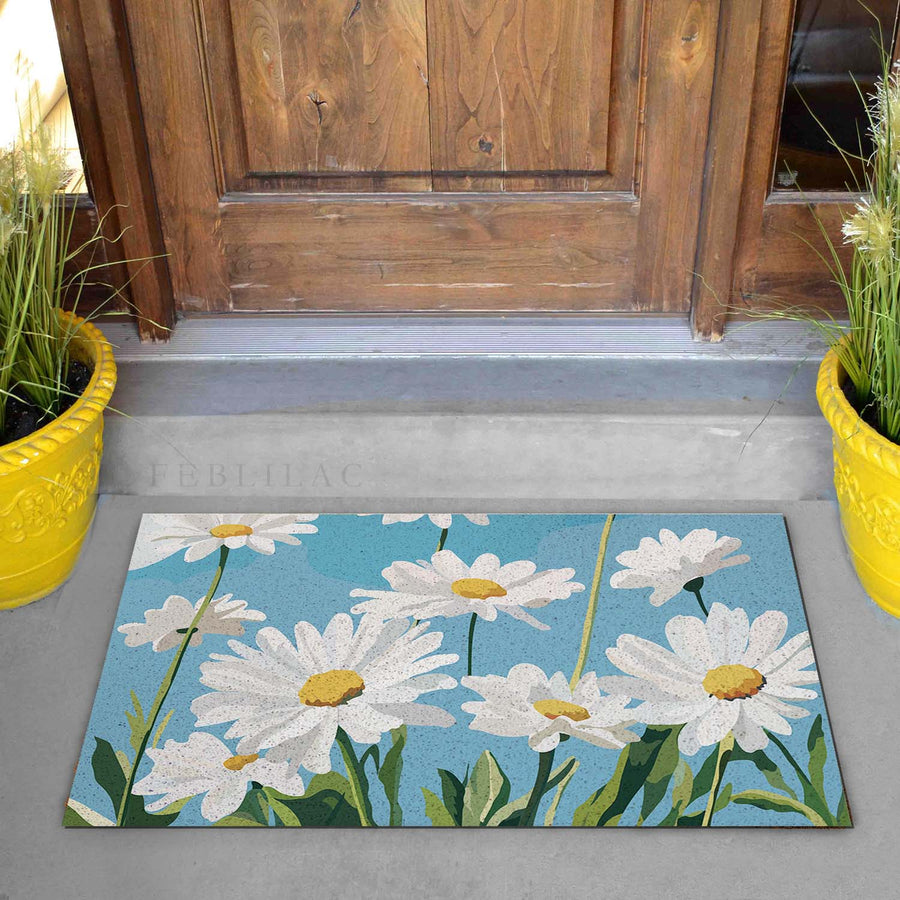 Feblilac Blue Sky Daisies PVC coil door mat on a doorstep with potted plants