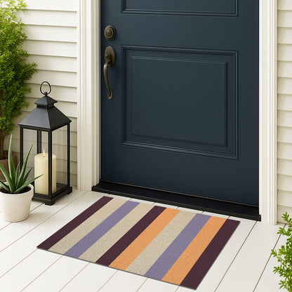 Feblilac Orange and Purple Stripes PVC coil door mat on a doorstep with potted plants