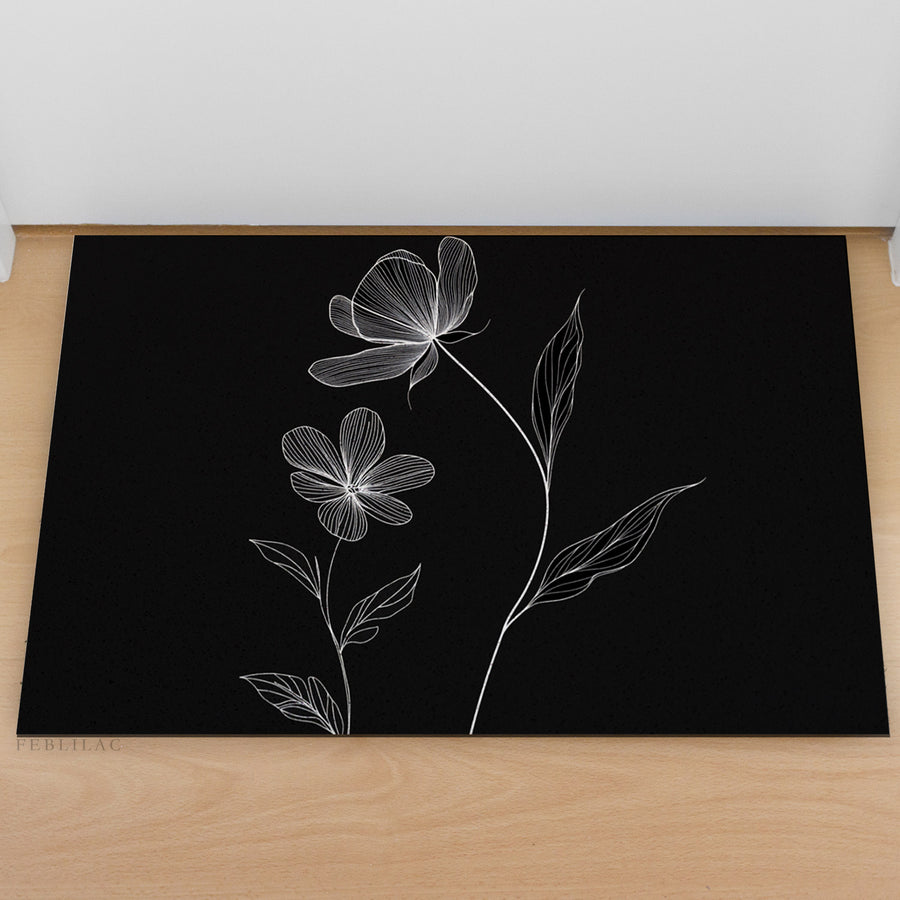 Feblilac Minimal Black and White Flowers PVC coil door mat at an entryway with a wooden door