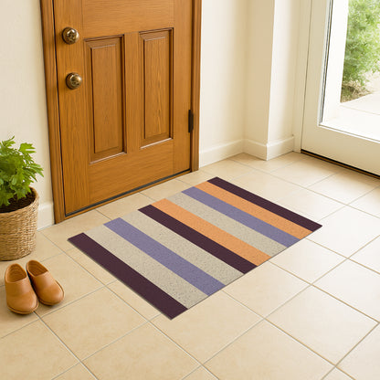 Feblilac Orange and Purple Stripes PVC coil door mat at an entryway with a wooden door