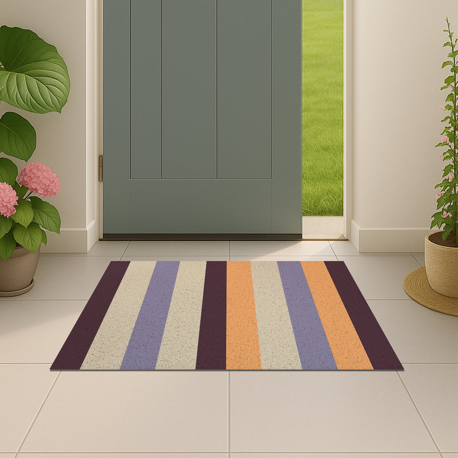 Feblilac Orange and Purple Stripes PVC coil door mat beside a doorway on grey stone