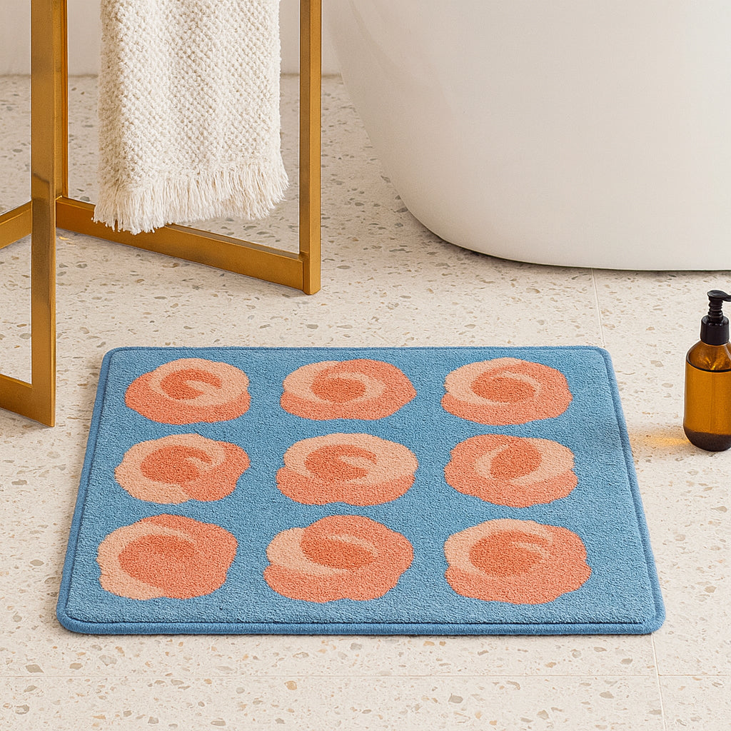 Feblilac Roses on Blue tufted bath mat by the sink with slippers and a towel basket