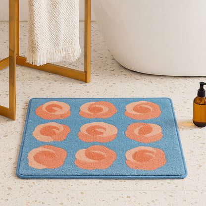 Feblilac Roses on Blue tufted bath mat by the sink with slippers and a towel basket