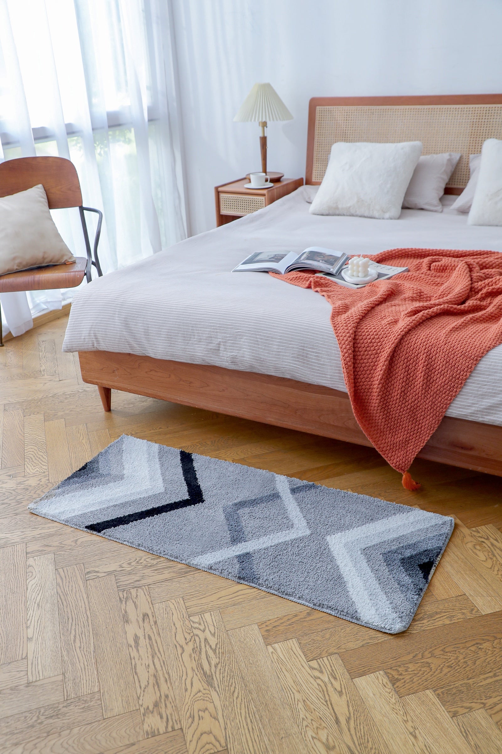 Grey geometric Feblilac runner beside a bed in a warm bedroom