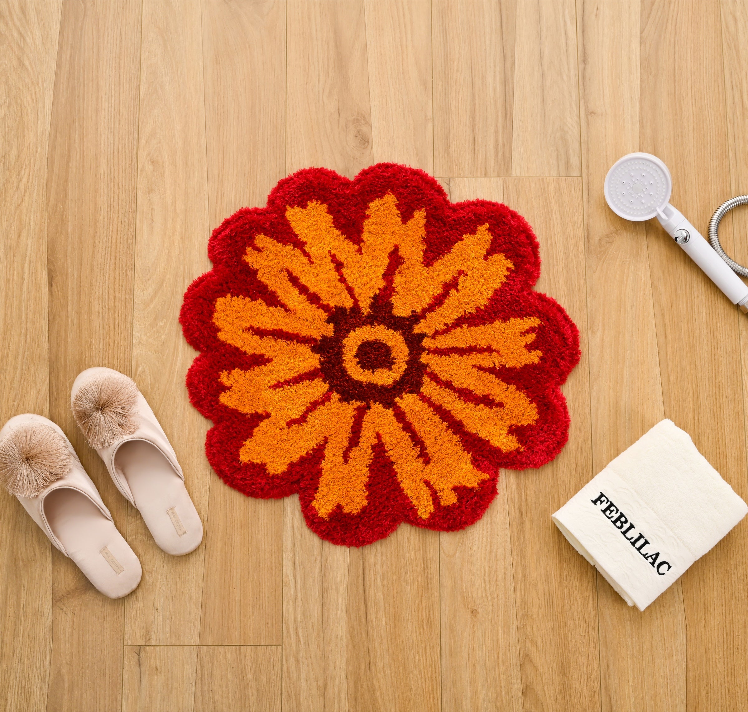 Orange flower-shaped Feblilac mat styled on a warm wood floor
